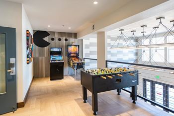 a games room with a foosball table and other games in a building